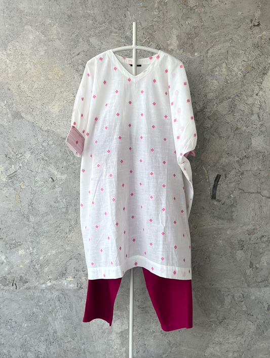 White cotton kaftan kurta with pink butti, wide sleeves, thread detailing by Indian designer Sonal Kabra – breathable summer wear.