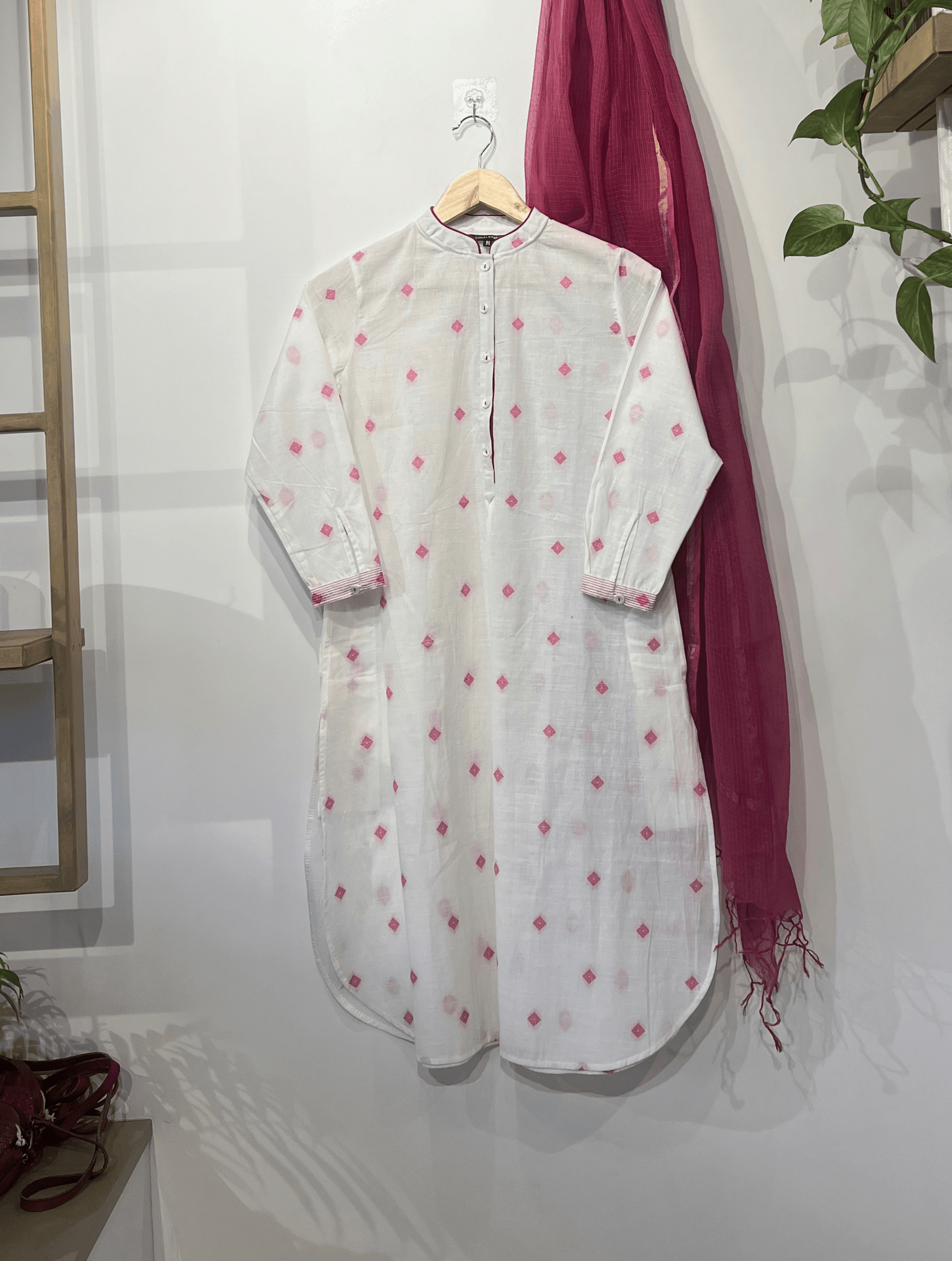 White cotton kurta with pink butti, front placket, side pockets, and 3/4th sleeves – Sonal Kabra Indian designer summer wear.