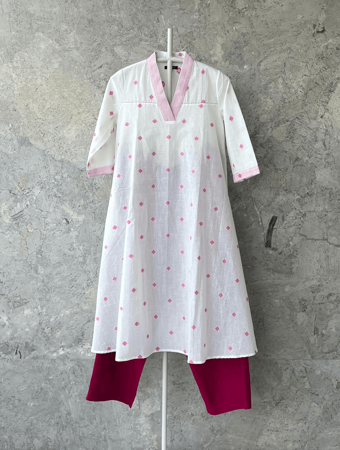 White fit and flare cotton kurta with pink butti, V-neck, and handcrafted detailing by Indian designer Sonal Kabra – summer collection.