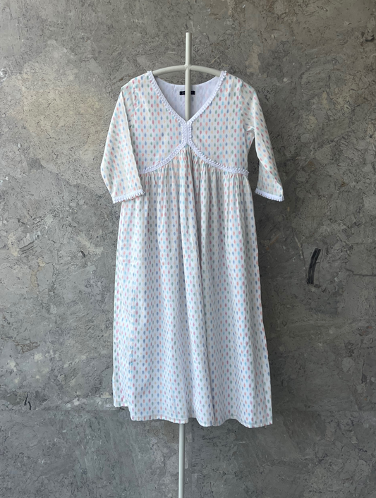 White cotton kurta with multicolor butti and lace detail, breathable summer wear by Indian designer Sonal Kabra from the Sunlit Stories collection.