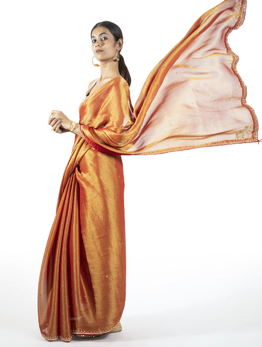Orange tissue saree with zardosi embroidery, tikki, moti, and kasab highlights – handcrafted Indian designer wear by Sonal Kabra.
