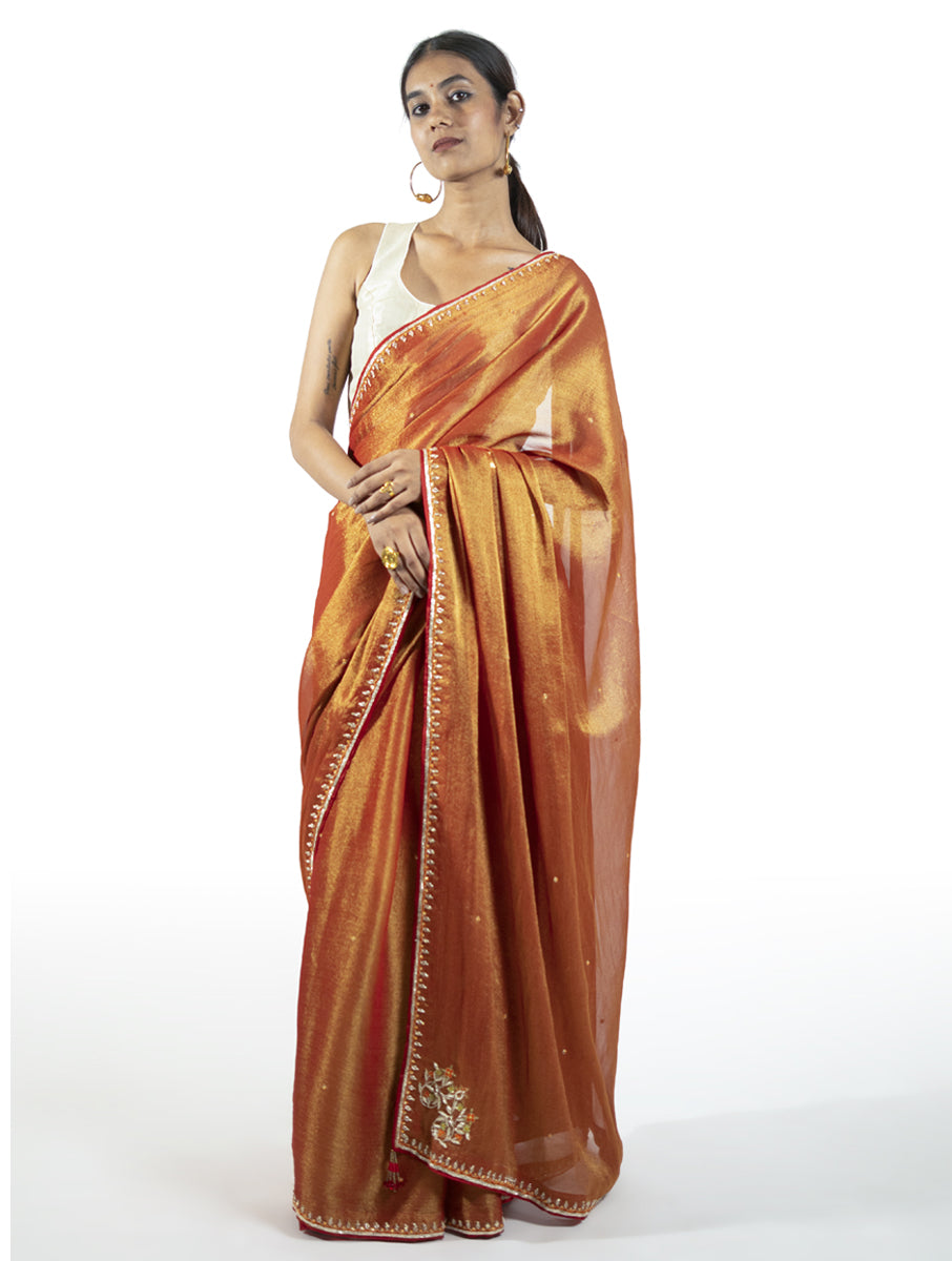 Red tissue saree with zardosi motifs, tikki, moti, and kasab highlights – handcrafted Indian designer wear by Sonal Kabra.

