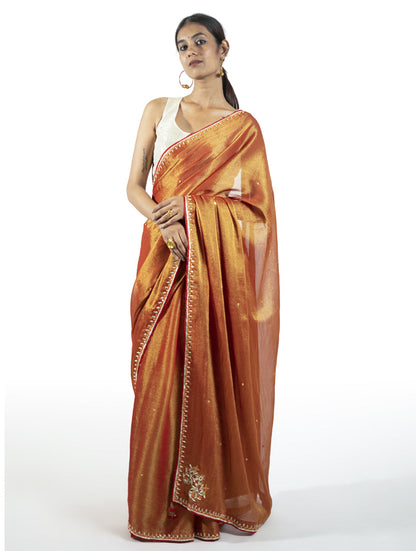 Red tissue saree with zardosi motifs, tikki, moti, and kasab highlights – handcrafted Indian designer wear by Sonal Kabra.
